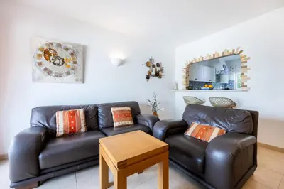 a living room with a leather couch and a table at CoolHouses Algarve, Luz, 1 bed flat, top floor, a stone's throw to the beach, Casa Isabell in Luz