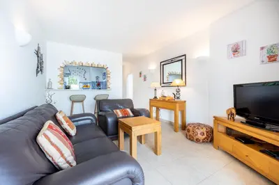 a living room with a leather couch and a flat screen tv at CoolHouses Algarve, Luz, 1 bed flat, top floor, a stone's throw to the beach, Casa Isabell in Luz