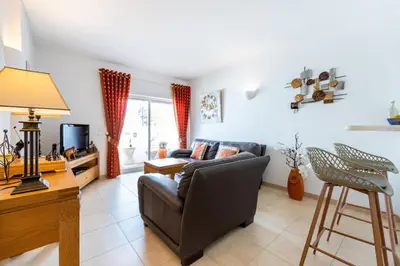 a living room with a couch and a tv at CoolHouses Algarve, Luz, 1 bed flat, top floor, a stone's throw to the beach, Casa Isabell in Luz