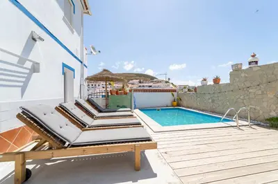 a patio with a swimming pool and a table at Villa O Altinho Carrapateira in Carrapateira