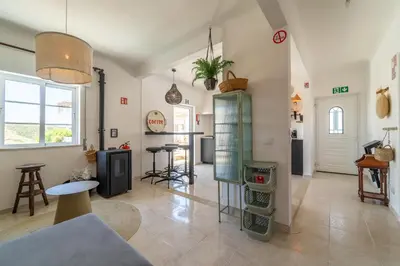 a living room with a table and some chairs at Villa O Altinho Carrapateira in Carrapateira