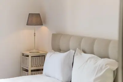 a bedroom with a bed with white pillows and a lamp at GuestReady - Sao Tiago in Old Town in Funchal