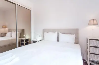 a bedroom with a large white bed and a mirror at GuestReady - Sao Tiago in Old Town in Funchal