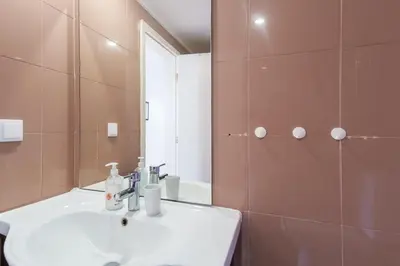 a bathroom with a white sink and a mirror at GuestReady - Sao Tiago in Old Town in Funchal