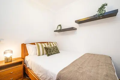 a bedroom with a bed and two shelves on the wall at Home to Stay by Homie in Funchal