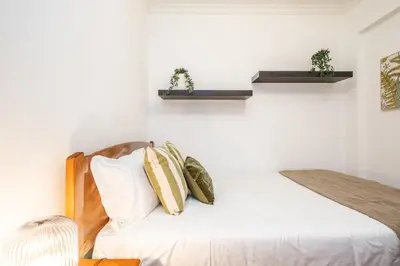 a bedroom with a bed with two plants on the wall at Home to Stay by Homie in Funchal