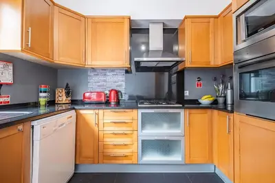 a kitchen with wooden cabinets and a stove top oven at Home to Stay by Homie in Funchal