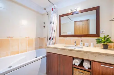 a bathroom with a sink and a tub and a mirror at Home to Stay by Homie in Funchal