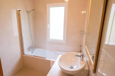 a bathroom with a sink and a shower and a toilet at Luxury villa with private heated pool, garden and views of the sea and mountains. in Arco da Calheta
