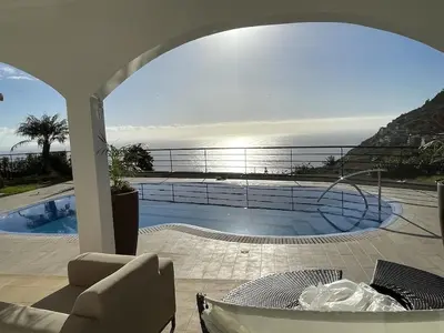 a view of a swimming pool from a house at Luxury villa with private heated pool, garden and views of the sea and mountains. in Arco da Calheta