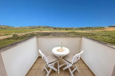 a table and chairs on a balcony with a view at Burgau Beach House in Burgau