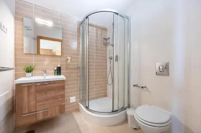 a bathroom with a shower and a toilet and a sink at Burgau Beach House in Burgau