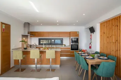 a kitchen and dining room with a table and chairs at Villa Hibiscus by An Island Apart in Calheta