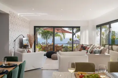 a living room with white furniture and a view of the ocean at Villa Hibiscus by An Island Apart in Calheta