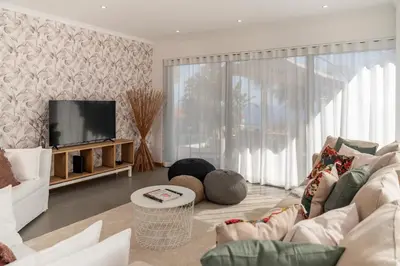 a living room with a couch and a television at Villa Hibiscus by An Island Apart in Calheta