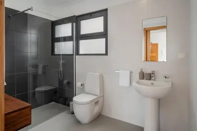 a bathroom with a toilet and a sink and a shower at Villa Hibiscus by An Island Apart in Calheta