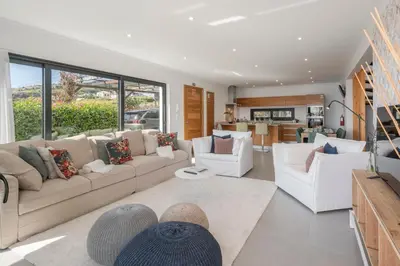 a living room with white furniture and a kitchen at Villa Hibiscus by An Island Apart in Calheta