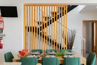a dining room with a table with chairs and a staircase at Villa Hibiscus by An Island Apart in Calheta