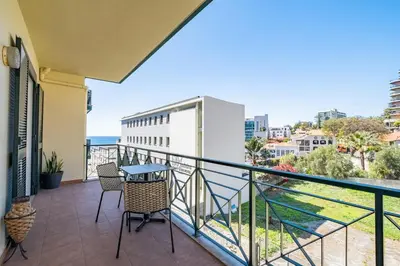 a balcony with a table and chairs and the ocean at Recanto da Princesa by Homie in Funchal