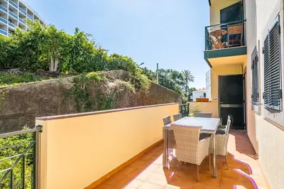 a patio with a table and chairs on a balcony at Recanto da Princesa by Homie in Funchal