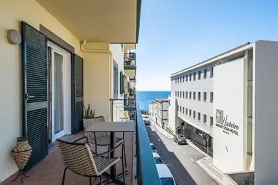 a balcony with chairs and a table and a view of the ocean at Recanto da Princesa by Homie in Funchal