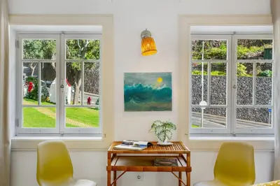 a living room with a blue couch and a table at Calheta Beach House T1 in Calheta