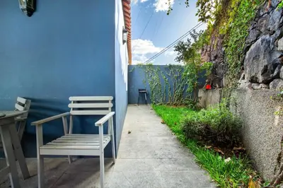 a chair sitting on a sidewalk next to a blue wall at Calheta Beach House T1 in Calheta