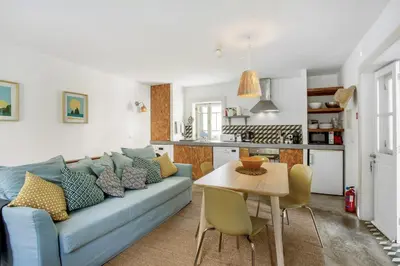 a living room with a blue couch and a table at Calheta Beach House T1 in Calheta