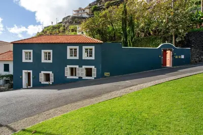 a blue house on the side of a road at Calheta Beach House T1 in Calheta