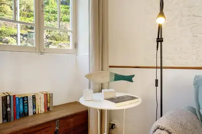 a room with a table with a lamp and a book at Calheta Beach House T2 in Calheta