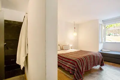a small bedroom with a bed and a window at Calheta Beach House T2 in Calheta