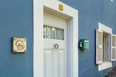 a blue building with a white door and a window at Calheta Beach House T2 in Calheta