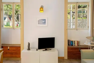 a living room with a tv on a white cabinet at Calheta Beach House T2 in Calheta