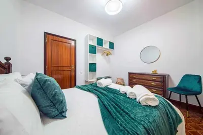 a large living room with a black couch and windows at Lombo Cesteiro Guesthouse in Tábua