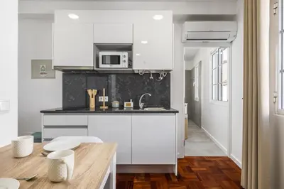 a kitchen with a counter top and a table at Ribeira do Esmeraldo by Homie in Funchal