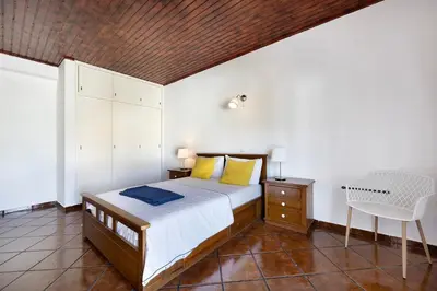 a bedroom with a white bed and a blue wall at Villa Oliveira in Aljezur