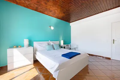 a bathroom with a toilet and a sink and a mirror at Villa Oliveira in Aljezur