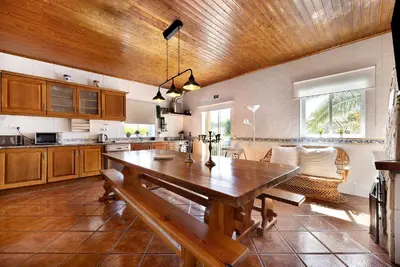 a large kitchen with a wooden table in it at Villa Oliveira in Aljezur