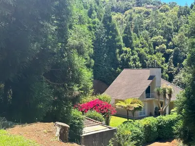 a house with pink flowers in front of a mountain at Quiet Place in Machico
