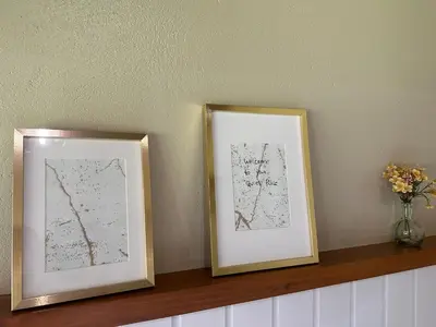 two framed pictures on a shelf with a vase of flowers at Quiet Place in Machico