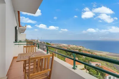 a balcony with two chairs and a view of the ocean at Santa Cruz Apartment with Sea View by Holiday Rental Madeira in Santa Cruz