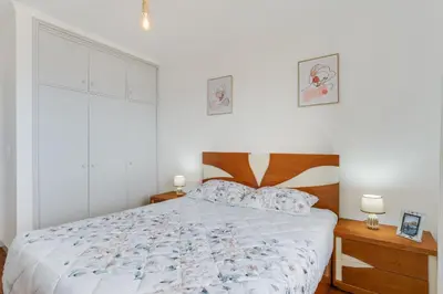 a bedroom with a bed and two night stands and two lamps at Santa Cruz Apartment with Sea View by Holiday Rental Madeira in Santa Cruz