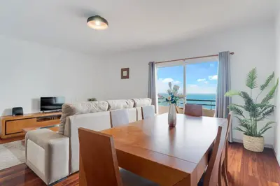 a living room with a table and a couch with a view at Santa Cruz Apartment with Sea View by Holiday Rental Madeira in Santa Cruz