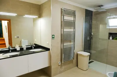 a bathroom with two sinks and a shower at Casa do Cantinho do Muro in São Vicente