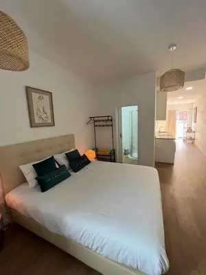 a bedroom with a large white bed with green pillows at Charming Funchal Studio II in Funchal