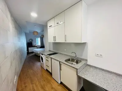 a kitchen with white cabinets and a sink at Charming Funchal Studio II in Funchal