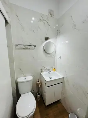 a white bathroom with a toilet and a sink at Charming Funchal Studio II in Funchal