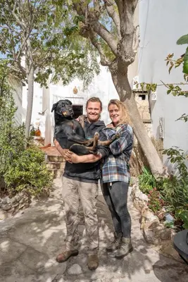 a man and a woman holding a black dog at Casa Carina Espiche in Espiche