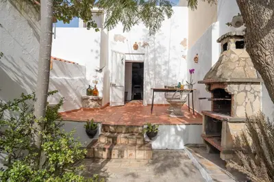 an outdoor patio with a table and an oven at Casa Carina Espiche in Espiche