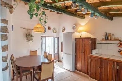 a kitchen and dining room with a table and a refrigerator at Casa Carina Espiche in Espiche